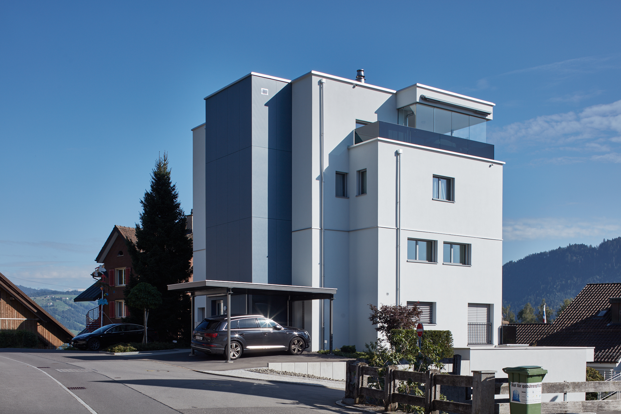 Weisses Mehrfamilienhaus mit Carport und Glasbrüstung an der Alten Landstrasse