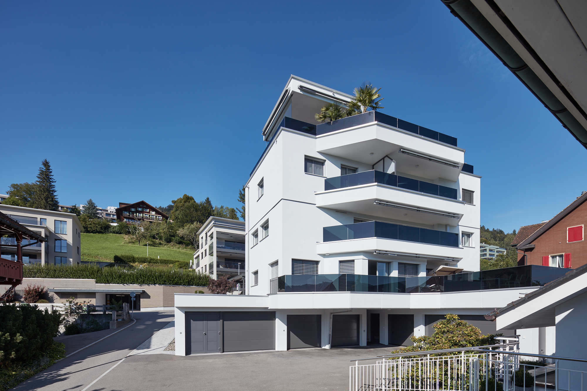 Terrassenhaus mit Balkonen, Garagentoren und Dachbepflanzung